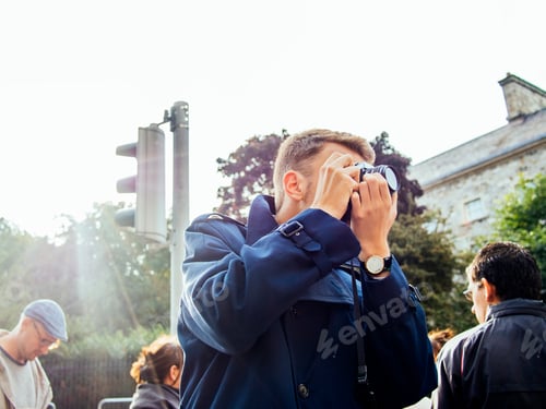 Preview: Man photographing in city against clear sky