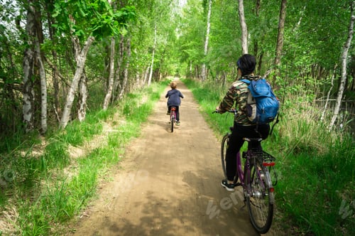Preview: Shot of an adult and a kid riding bicycles in a forest