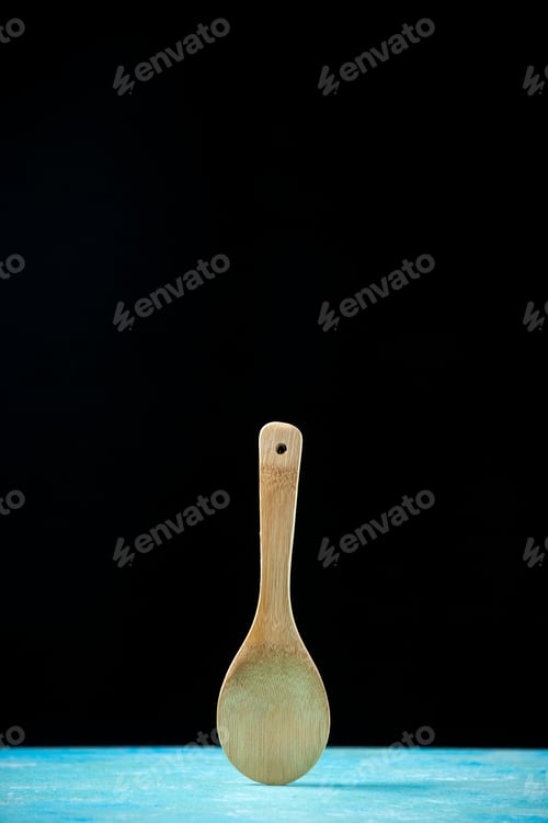 Preview: front view round wooden spoon placed upright on black background copy space