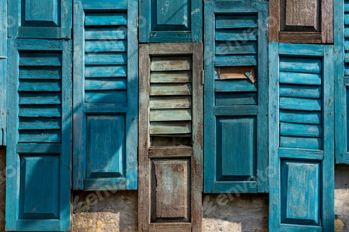 Preview: Vintage blue wooden shutters of various styles create a textured, artistic wall pattern