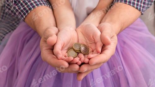 Preview: Dad and his daughter holding coins in hands together