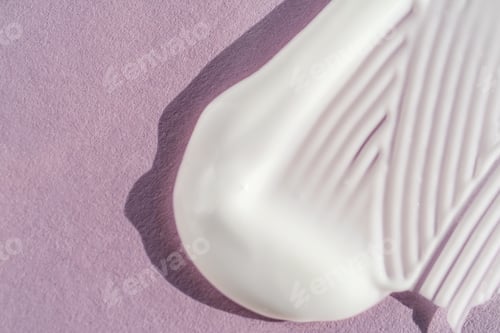 Preview: The texture of the white cream on a purple background.