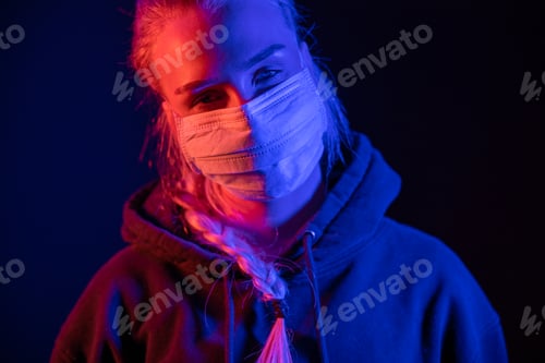 Preview: Exhausted or sick woman in protective face mask with multi colored lights