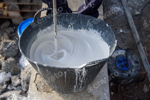 Preview: Worker mixing plaster in bucket