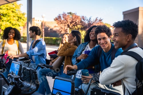 Preview: Diverse students smiling at bike sharing station on campus