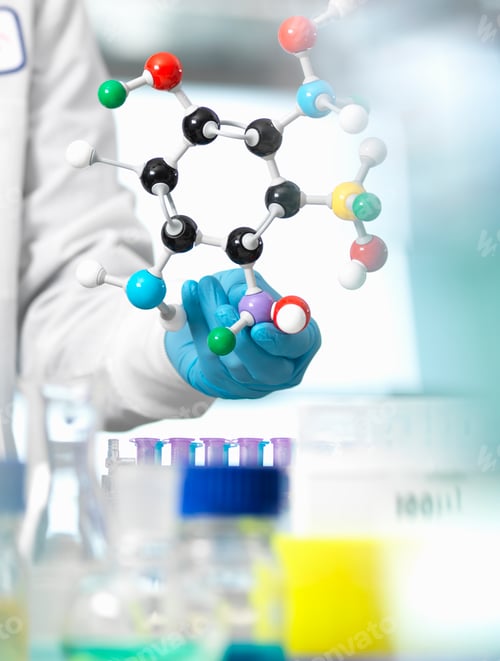 Preview: Researcher using a molecular model to understand a chemical formula in a laboratory