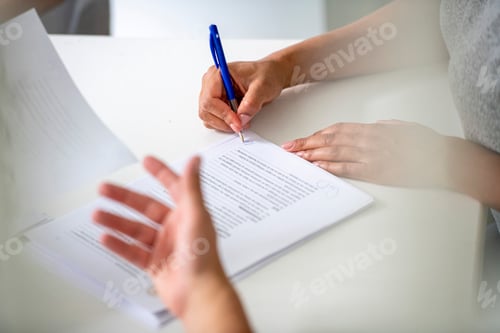 Preview: Signing important documents at a bright desk.