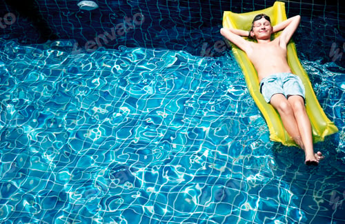 Preview: Teenage boy relaxing with pool mattress