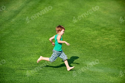 Preview: Happy boy running at the green golf course at sunny day