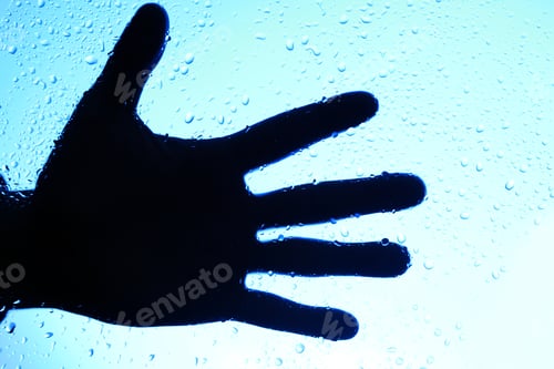 Preview: Silhouette of human hand over glass with drops