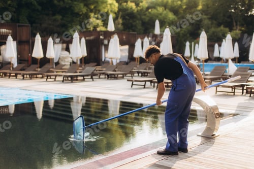 Preview: Pool cleaner using cleaning net in a swimming pool during summer