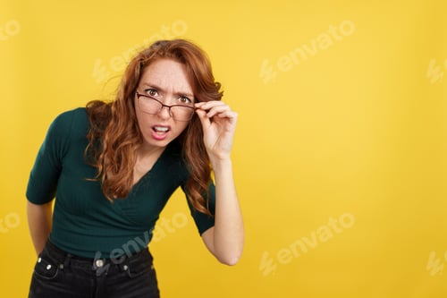 Preview: Woman with Glasses Expressing Confusion on Yellow Background