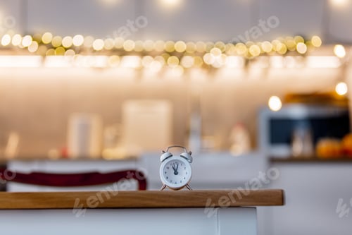 Preview: little alarm clock on a table with Christmas lights