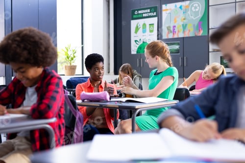 Preview: Happy, diverse female school teacher and schoolgirl practicing sign language in class