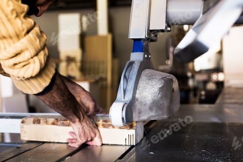 Preview: Carpenter cutting wood using table saw in workshop