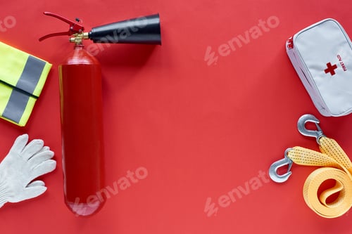 Preview: flat lay with fire extinguisher, first aid kit and automotive accessories on red background
