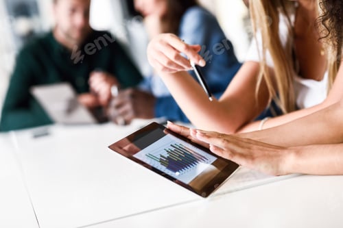 Preview: Group of young men and woman coworking with tablet computer