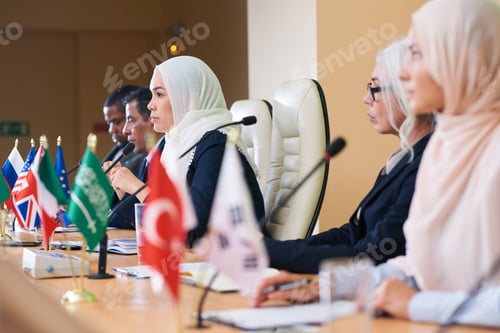 Preview: Row of serious intercultural delegates listening attentively