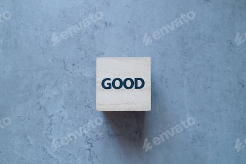 Preview: Close-up of wooden block with Good text on old concrete background