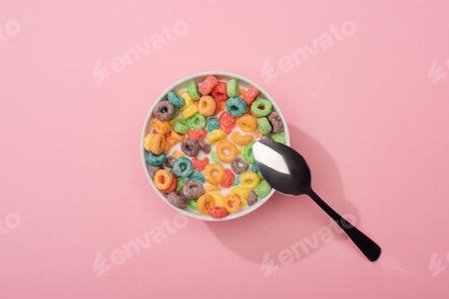 Preview: Top View of Bright Colorful Breakfast Cereal in Bowl With Spoon on Pink Background