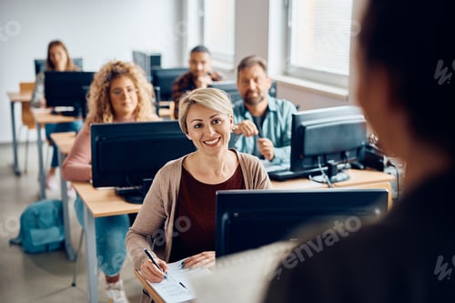 Preview: Happy mid adult woman attending computer class at the university.