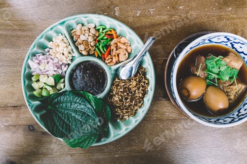 Preview: Betel leaf wrap and eggs and pork in sweet brown soup, Thai food on the table