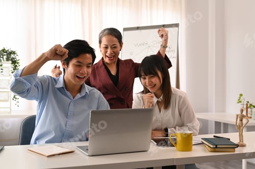 Preview: Happy young employee with senior manager celebrating corporate success or victory at office.
