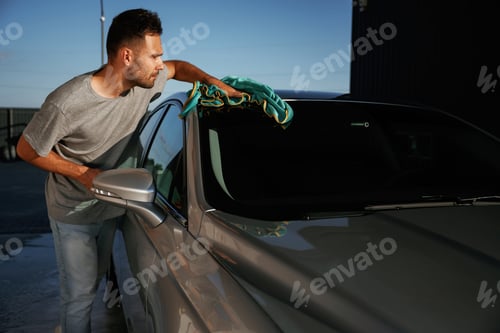 Preview: Working, polishing the automobile. Man is with his car outdoors