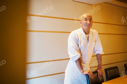 Preview: A chef , an itamae or master sushi chef wearing white jacket and apron.
