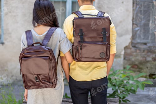 Preview: Back of woman and man with brown leather backpack