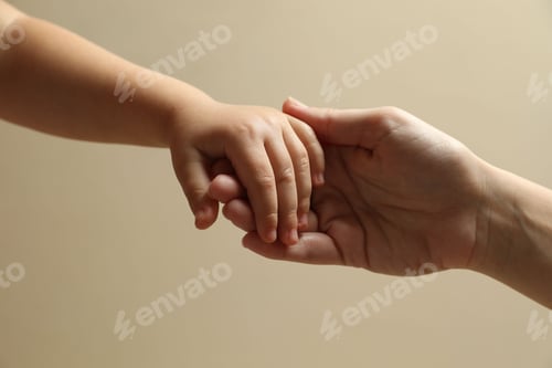 Preview: Mother and child holding hands on beige background, closeup