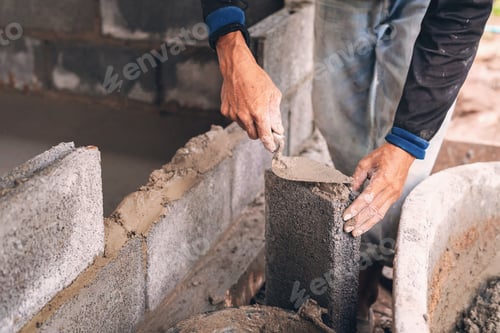 Preview: hand of worker plastering cement on brick wall at construction site
