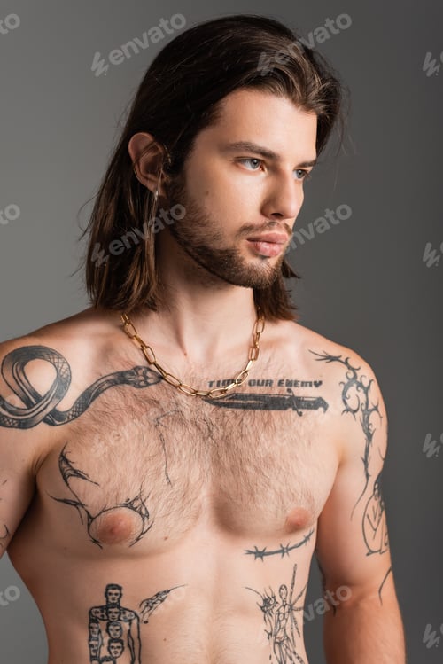 Preview: Portrait of shirtless tattooed man looking away isolated on grey