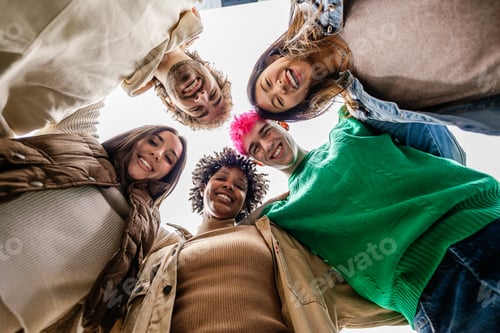 Preview: Smiling young group of people standing together in circle at city street