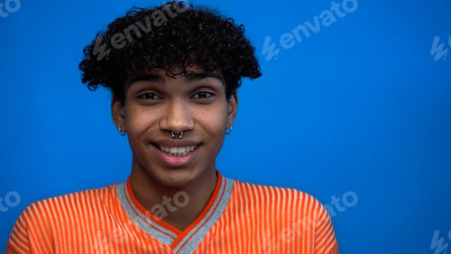 Preview: Young african american man smiling at camera isolated on blue
