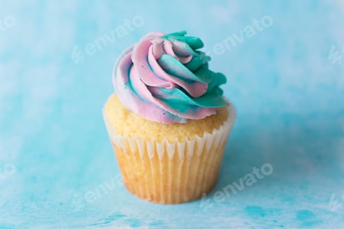Preview: Colorful Frosted Cupcake on a Blue Background