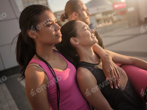 Preview: Portrait of pretty girls in sportswear friendly hugging