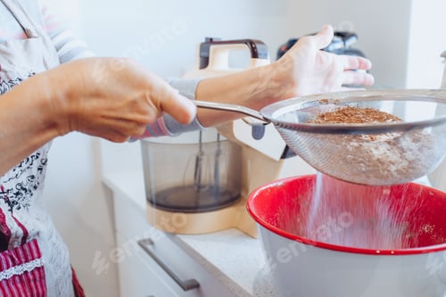 Preview: Adult Baking at Home Sifting Flour into Bowl