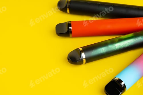Preview: Colorful disposable electronic cigarettes on yellow background