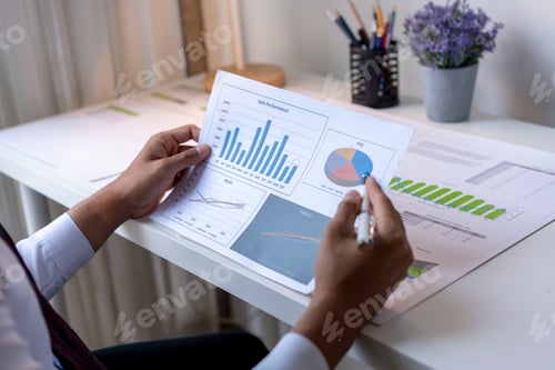 Preview: Analyst Reviewing Sales Performance Charts on Desk