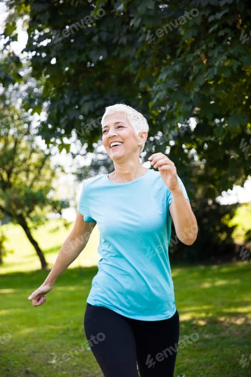 Preview: Senior woman jogging through park