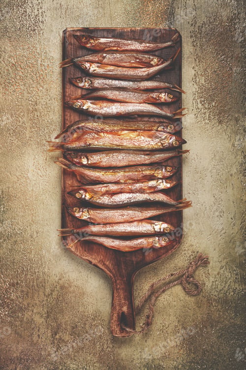Preview: cold smoked capelin, on a wooden chopping board, no people,