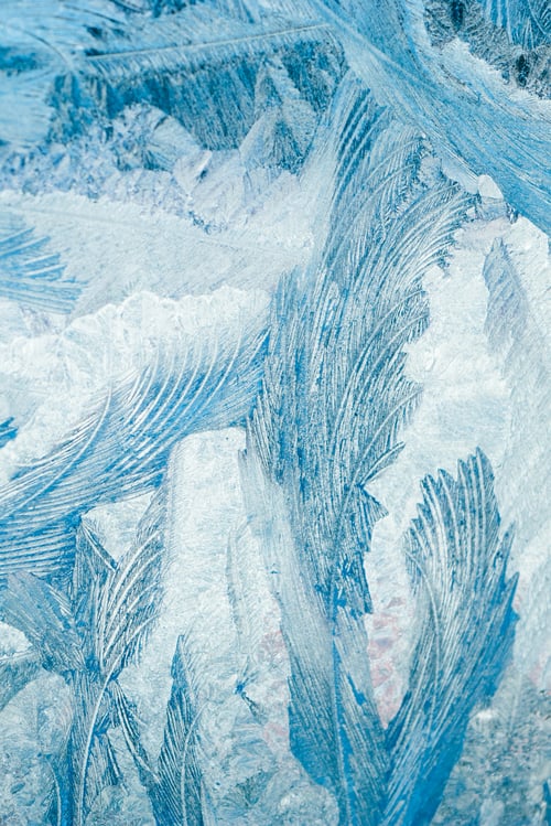 Preview: Winter frosty patterns on glass. Christmas festive background. Ice crystals on window.