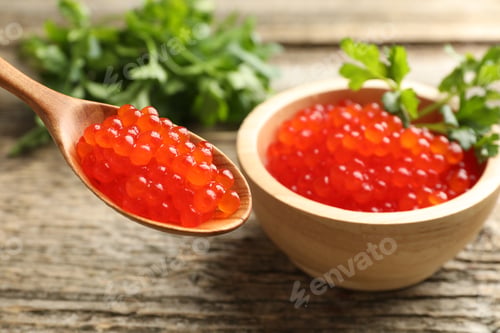 Preview: Red caviar and parsley on wooden table, closeup