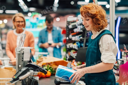 Preview: Cashier scanning groceries at supermarket checkout counter