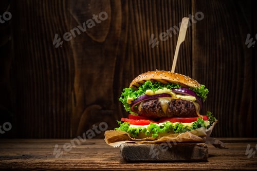 Preview: Tasty Big Burger in Bun on Wooden Background with Copy Space