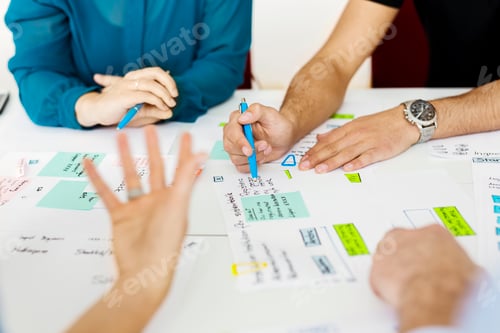 Preview: Colleagues sitting by conference table and brainstorming