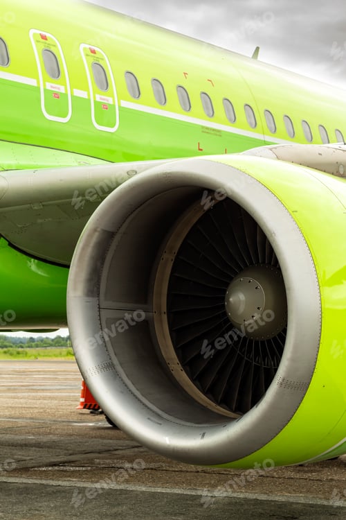 Preview: close-up of aircraft engine. green airplane and turbine detail on cloudy sky background at dawn.