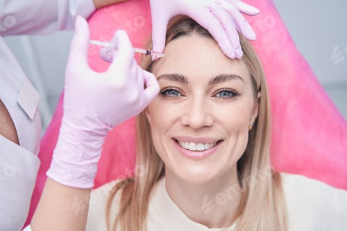 Preview: Smiling patient receiving subcutaneous injection into forehead