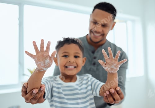 Preview: Shot of an adorable little boy washing his hands with the help of his father at home